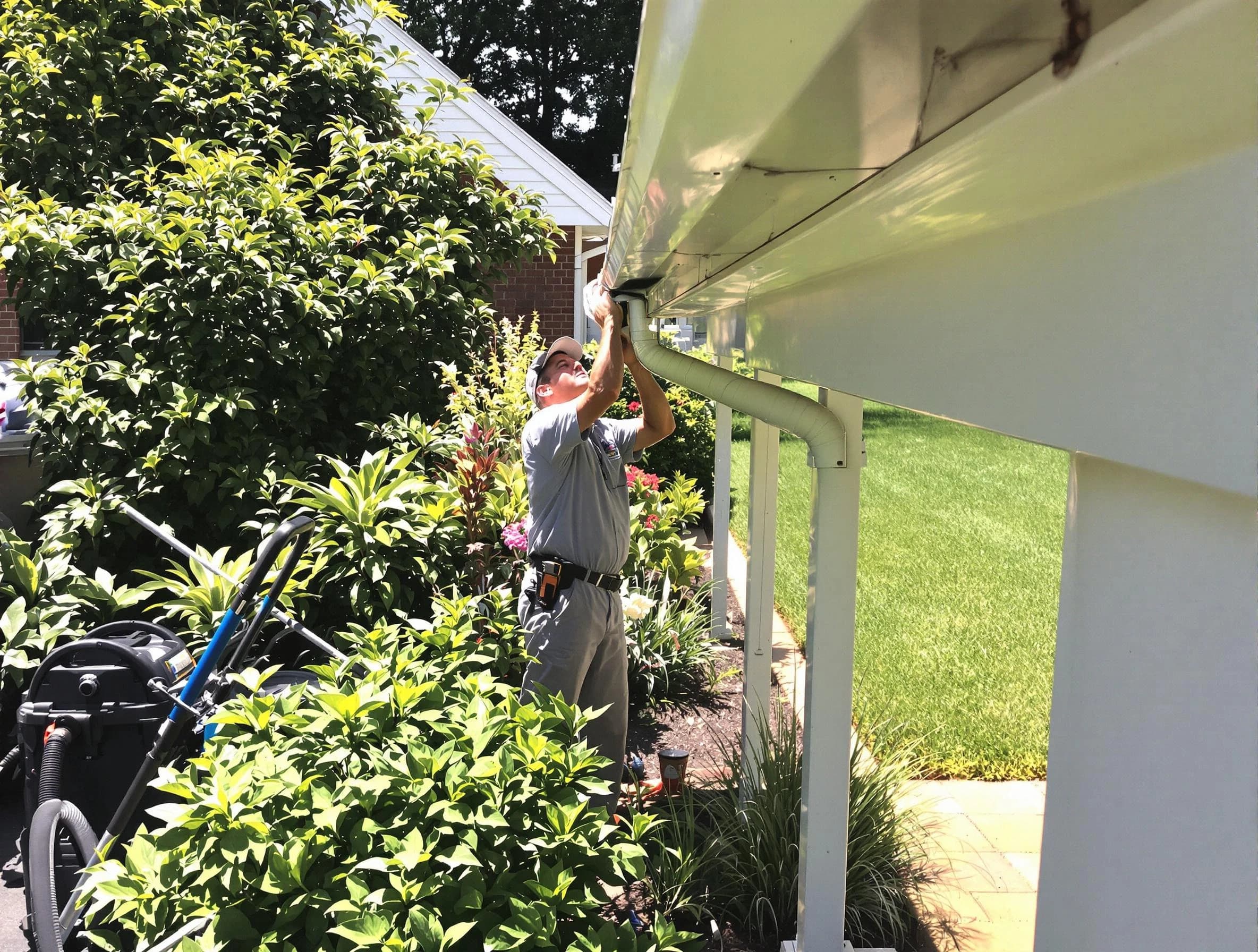 Technician flushing a blockage from a downspout in Kent, OH